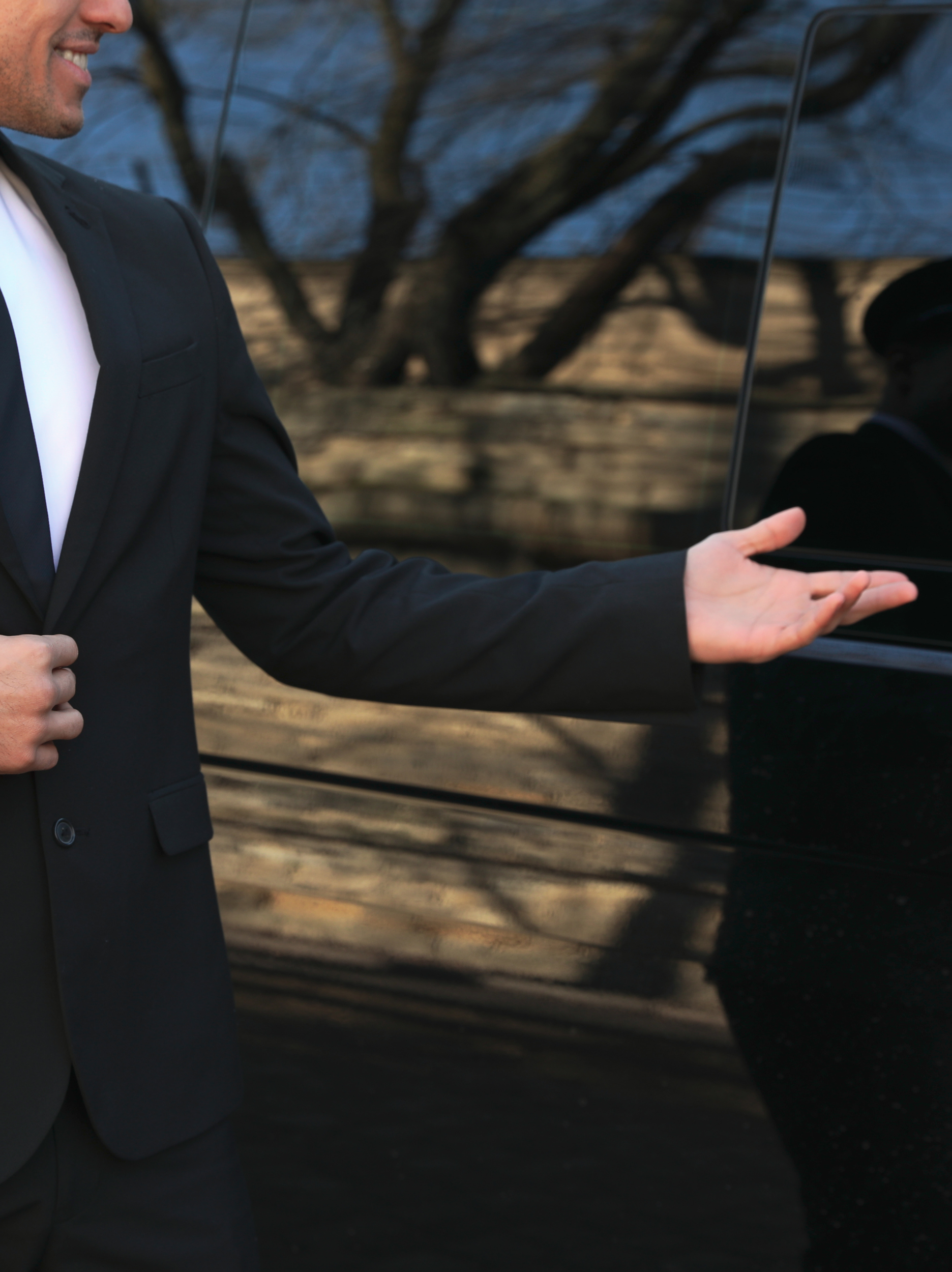 main d'un chauffeur privé qui désigne la porte